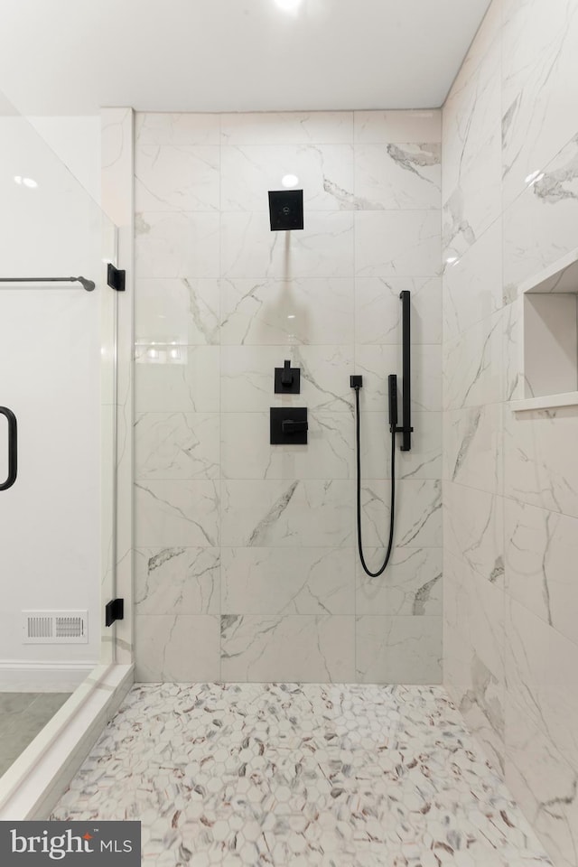 bathroom with a shower with door