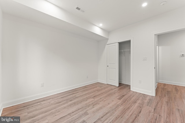 unfurnished bedroom with light hardwood / wood-style floors and a closet