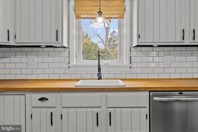 kitchen with wood counters, sink, white cabinetry, decorative light fixtures, and dishwasher