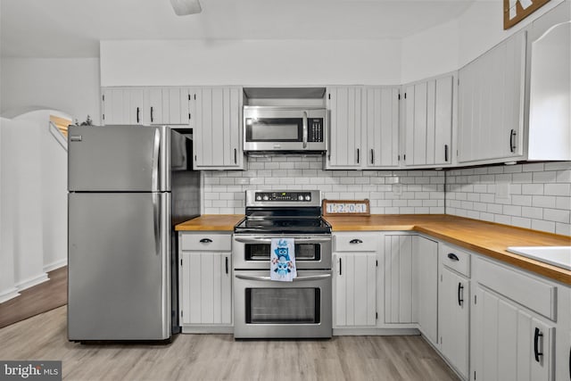 kitchen featuring white cabinetry, tasteful backsplash, stainless steel appliances, and light hardwood / wood-style floors