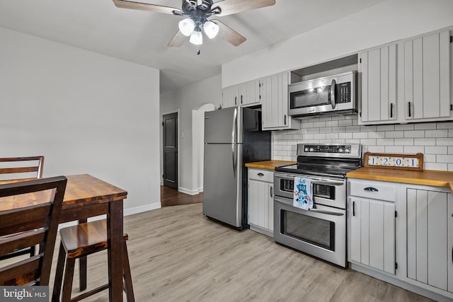 kitchen featuring tasteful backsplash, ceiling fan, appliances with stainless steel finishes, and light wood-type flooring