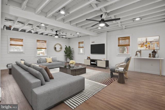 living room with hardwood / wood-style flooring, ceiling fan, and beam ceiling