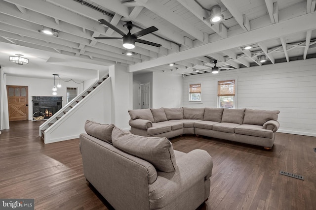 living room with beam ceiling, dark wood-type flooring, and ceiling fan