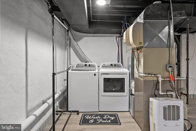 laundry room with light hardwood / wood-style flooring and washer and clothes dryer