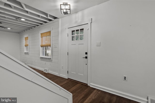 entryway featuring wooden walls and dark hardwood / wood-style flooring