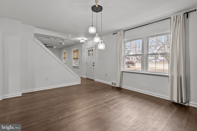 unfurnished dining area with dark wood-type flooring