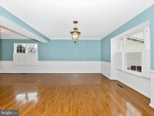 spare room with crown molding, an inviting chandelier, and light hardwood / wood-style flooring