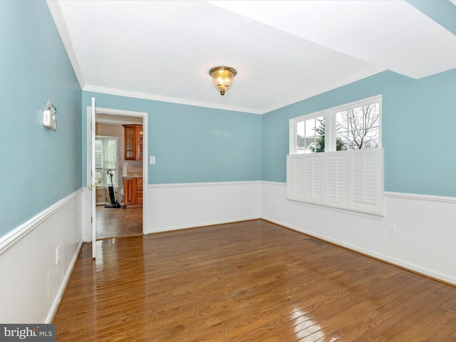 unfurnished room featuring hardwood / wood-style flooring and ornamental molding