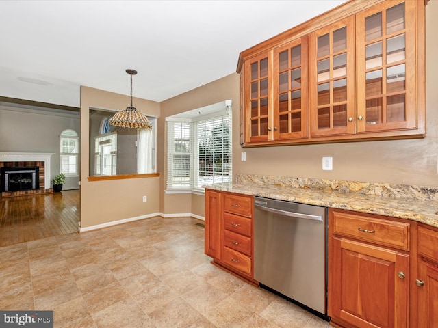 kitchen featuring pendant lighting, a fireplace, light stone countertops, and dishwasher