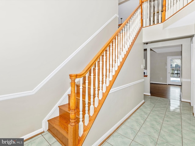 stairs featuring tile patterned floors and a high ceiling