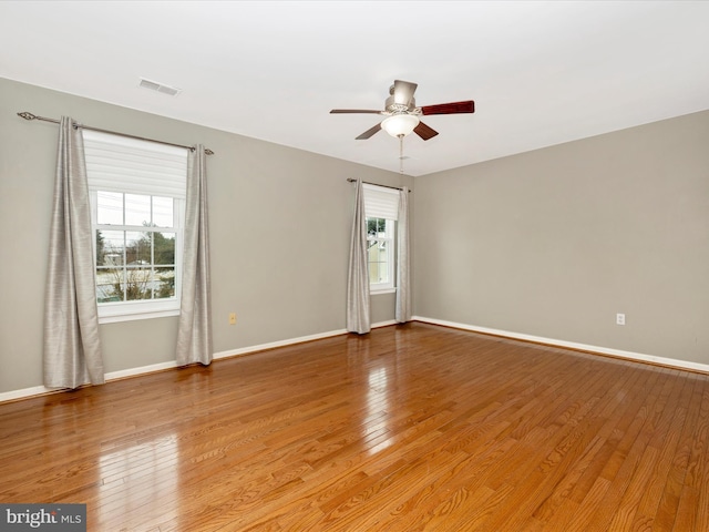 spare room with ceiling fan, plenty of natural light, and light hardwood / wood-style floors