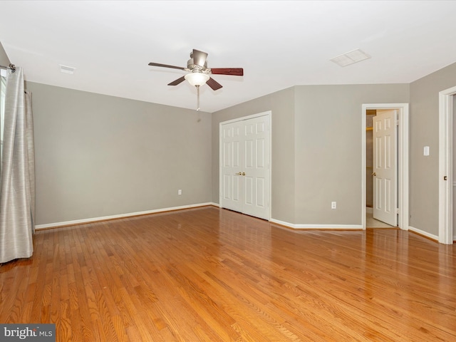 unfurnished bedroom with hardwood / wood-style flooring, ceiling fan, and a closet