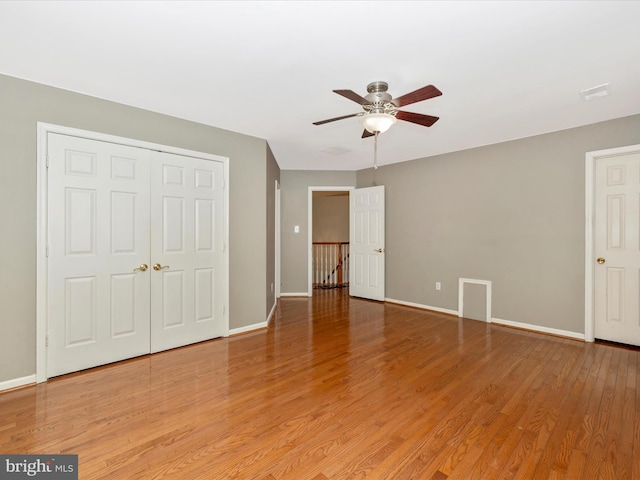 unfurnished bedroom with ceiling fan, hardwood / wood-style floors, and a closet