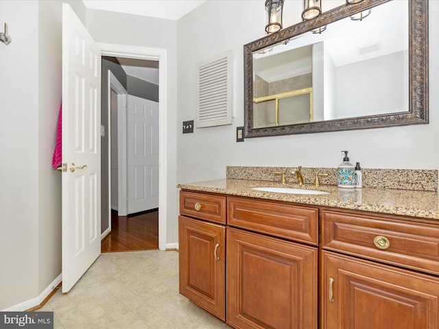 bathroom featuring vanity and an enclosed shower