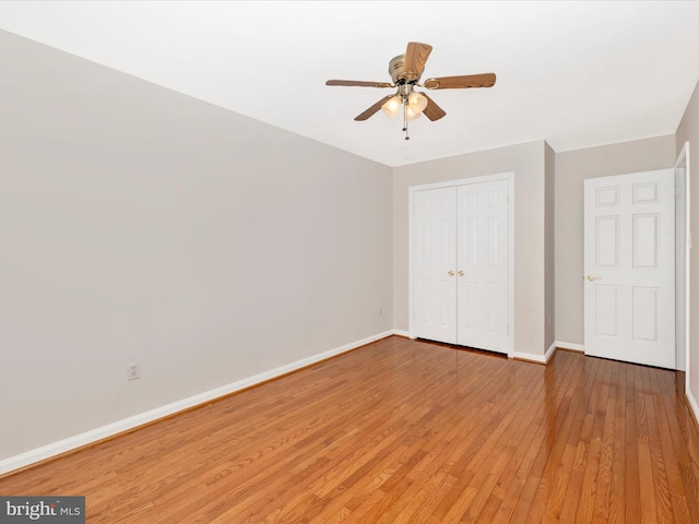 unfurnished bedroom featuring hardwood / wood-style flooring, a closet, and ceiling fan