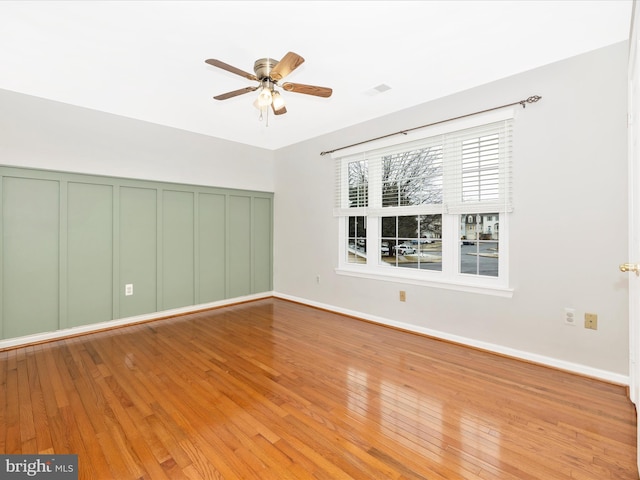 spare room featuring hardwood / wood-style floors and ceiling fan