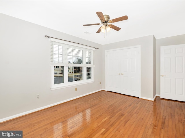 unfurnished bedroom with hardwood / wood-style floors, a closet, and ceiling fan