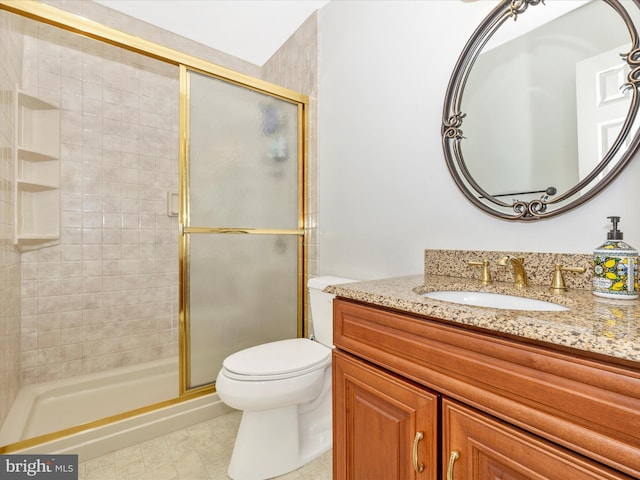 bathroom featuring vanity, an enclosed shower, and toilet