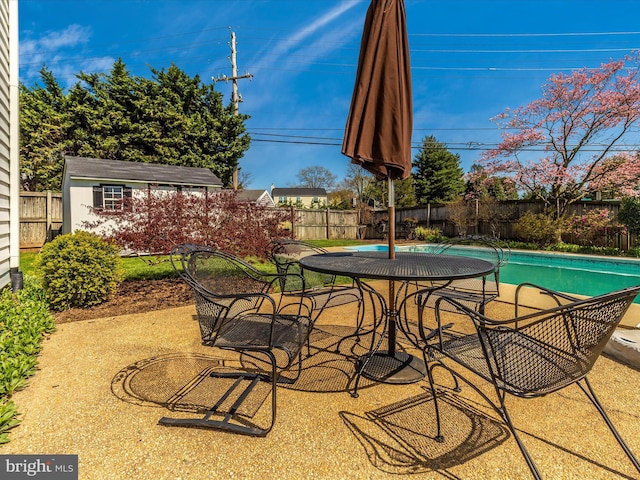 view of patio with a shed and a fenced in pool