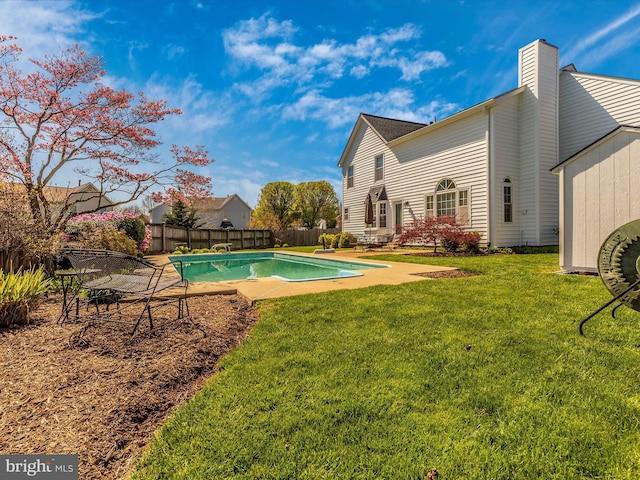 view of pool with a patio and a lawn