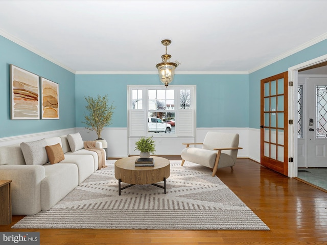 living room featuring crown molding, wood-type flooring, and a notable chandelier