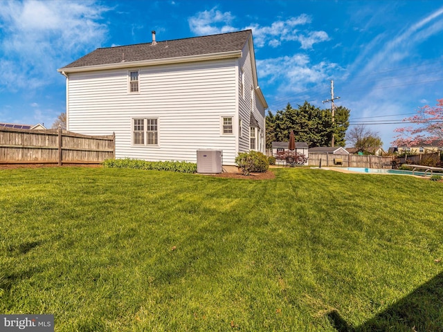 back of property with cooling unit, a fenced in pool, a yard, and a patio area