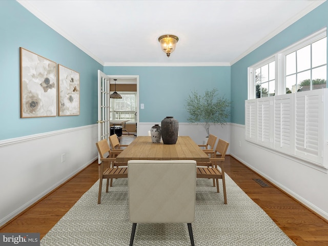 dining space featuring crown molding and hardwood / wood-style flooring