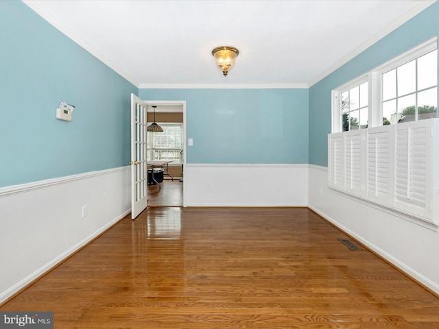 unfurnished room with hardwood / wood-style flooring, ornamental molding, and plenty of natural light