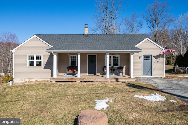 view of front of home with covered porch and a front lawn