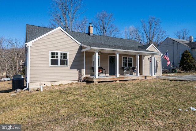 view of front of home with a front lawn, central air condition unit, and covered porch