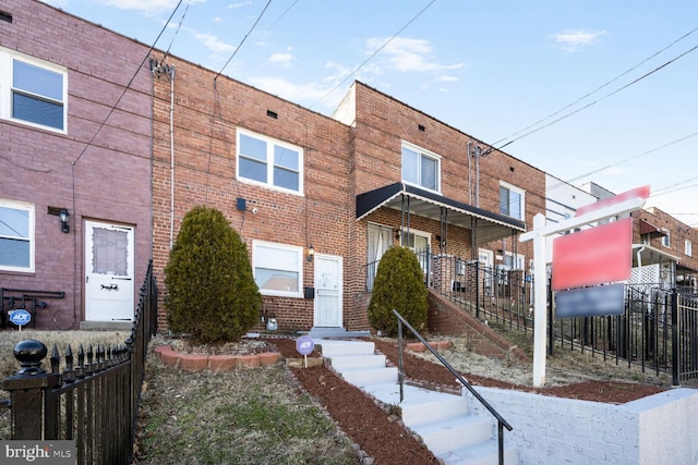 townhome / multi-family property featuring fence and brick siding