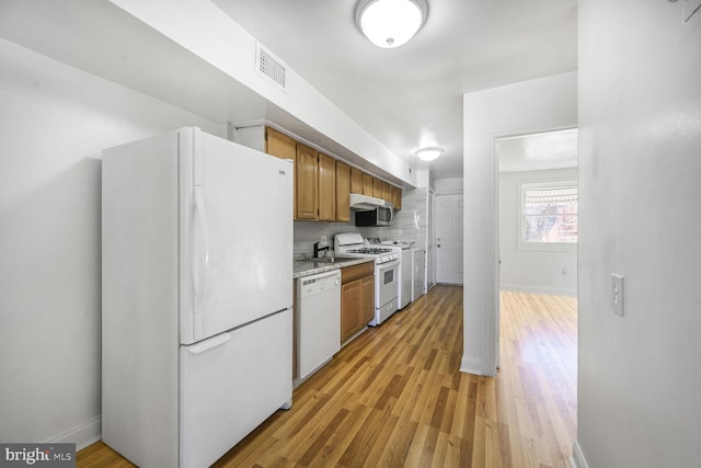 kitchen with light wood-style floors, white appliances, visible vents, and brown cabinetry