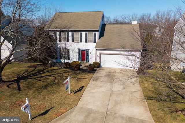 colonial house with a garage and a front yard