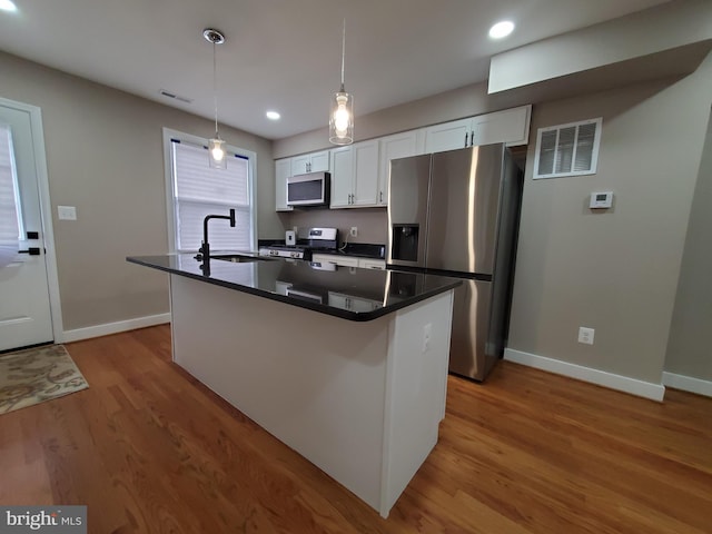 kitchen featuring a kitchen island, appliances with stainless steel finishes, sink, and white cabinets