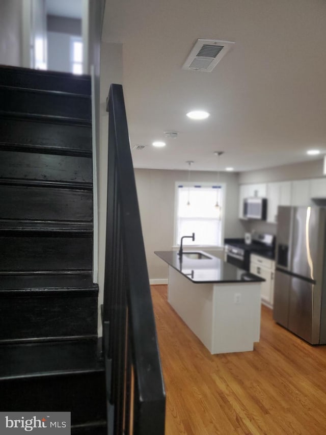 stairs featuring sink and hardwood / wood-style floors