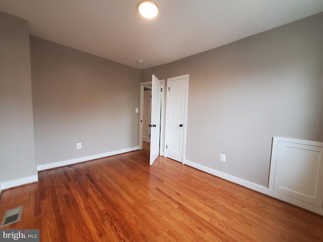 empty room with hardwood / wood-style flooring