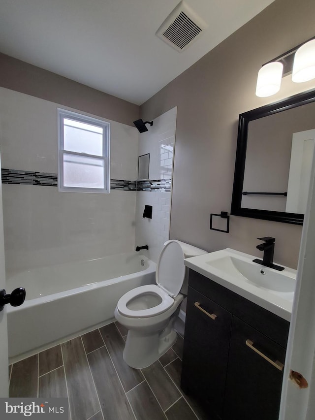 full bathroom featuring tiled shower / bath combo, vanity, and toilet