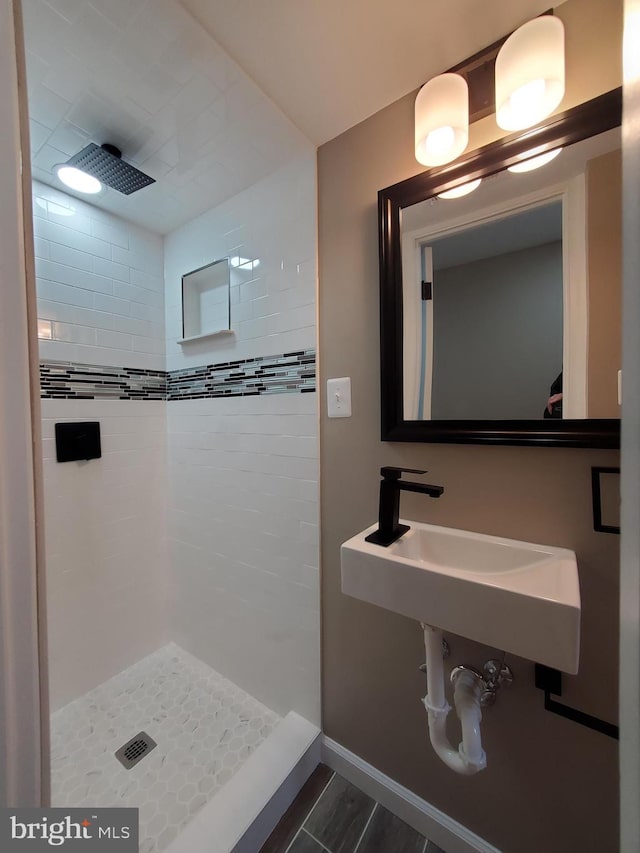 bathroom featuring tiled shower and sink