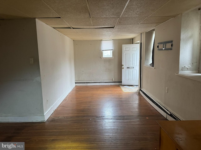 unfurnished room with hardwood / wood-style floors, a paneled ceiling, baseboards, and a baseboard radiator