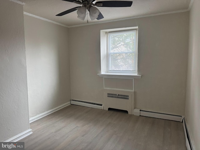 spare room featuring radiator, crown molding, a baseboard heating unit, wood finished floors, and a baseboard radiator