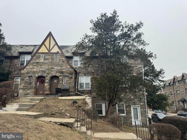 tudor-style house featuring stone siding