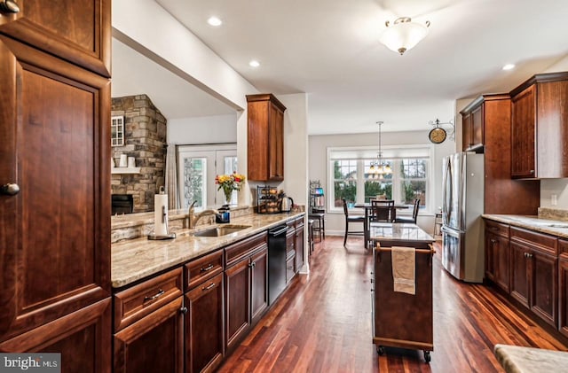 kitchen featuring dark wood-type flooring, sink, stainless steel fridge, dishwasher, and pendant lighting