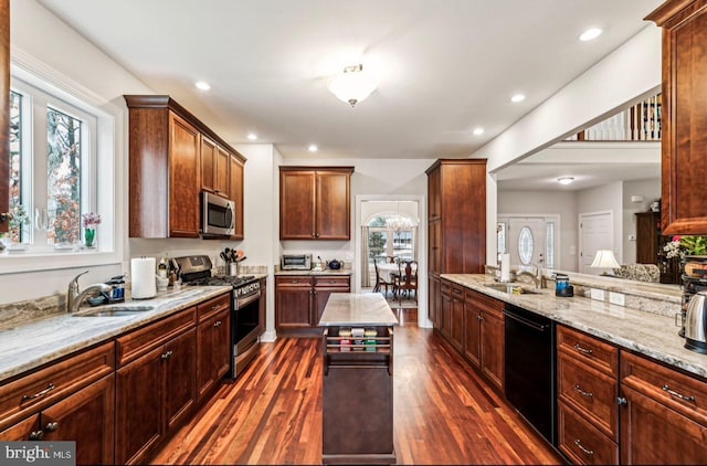 kitchen with stainless steel appliances, dark hardwood / wood-style floors, light stone countertops, and sink