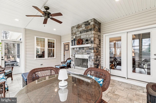 interior space featuring a fireplace, french doors, and ceiling fan