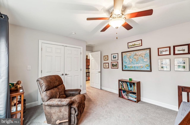 living area featuring ceiling fan and carpet