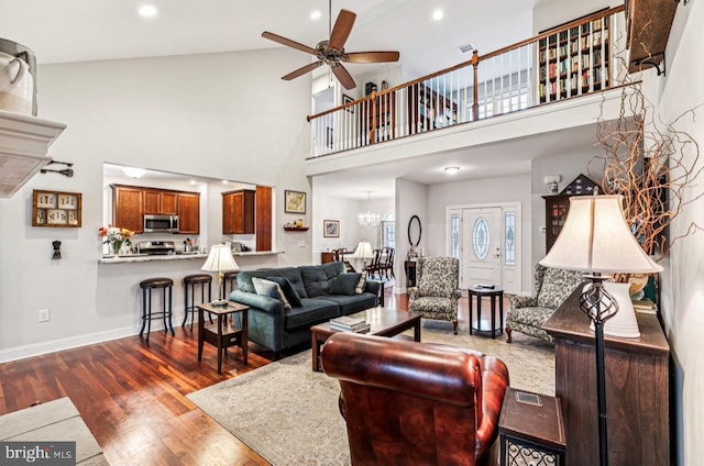 living room featuring hardwood / wood-style flooring, a high ceiling, and ceiling fan