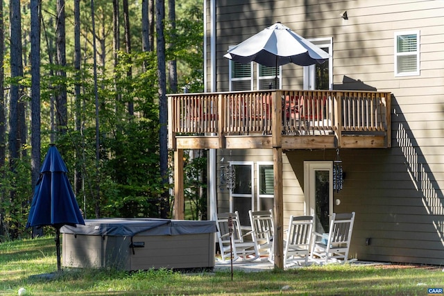 back of property featuring a hot tub, a patio, and a deck