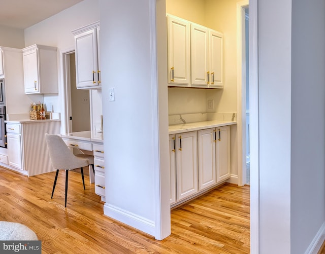 kitchen with white cabinetry, light hardwood / wood-style flooring, and stainless steel appliances