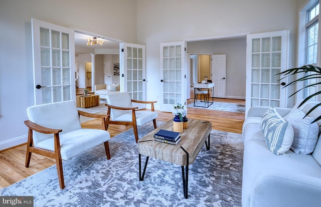 living room featuring a high ceiling, wood-type flooring, and french doors