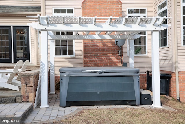 exterior space featuring a hot tub and a pergola